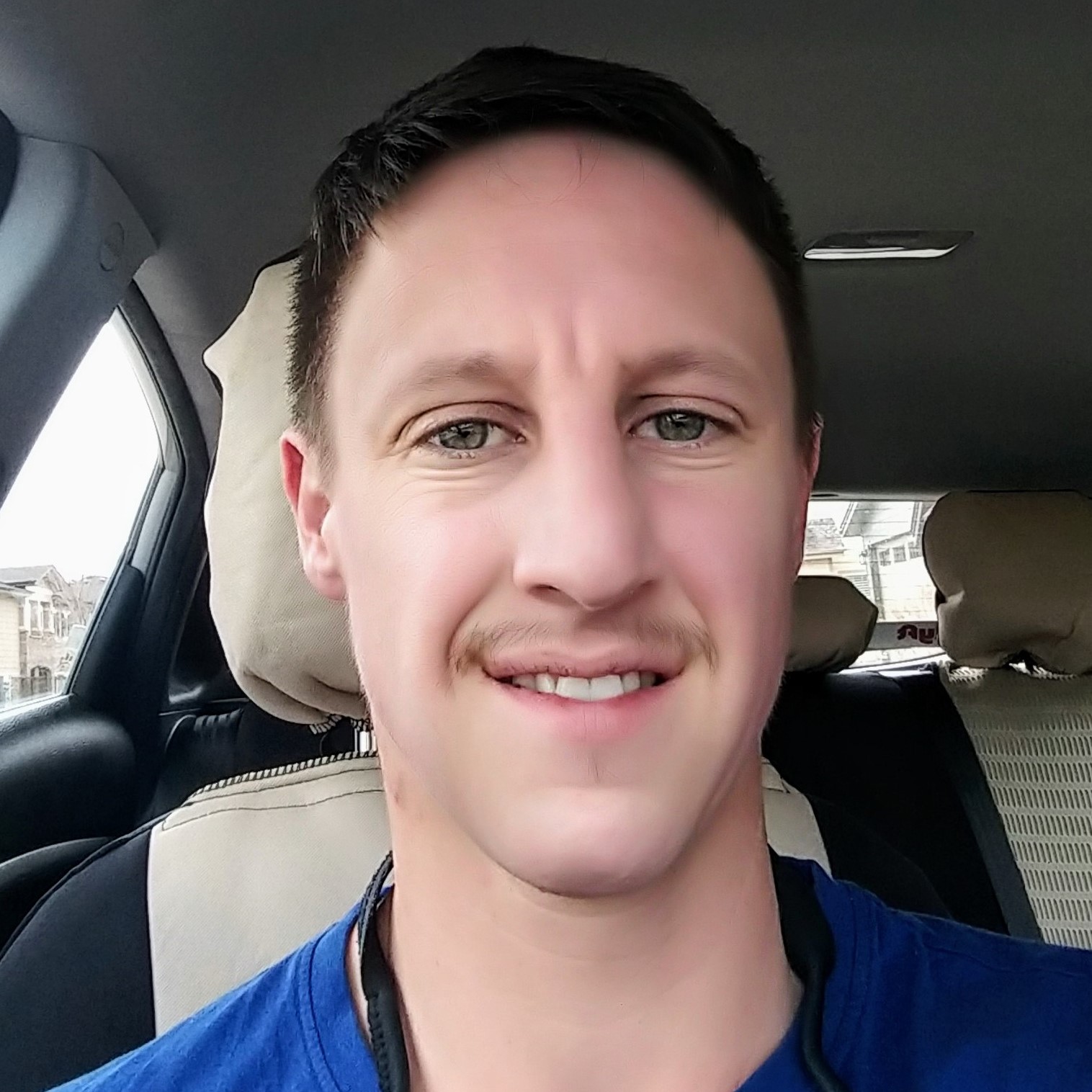 Headshot of Sam smiling in car.